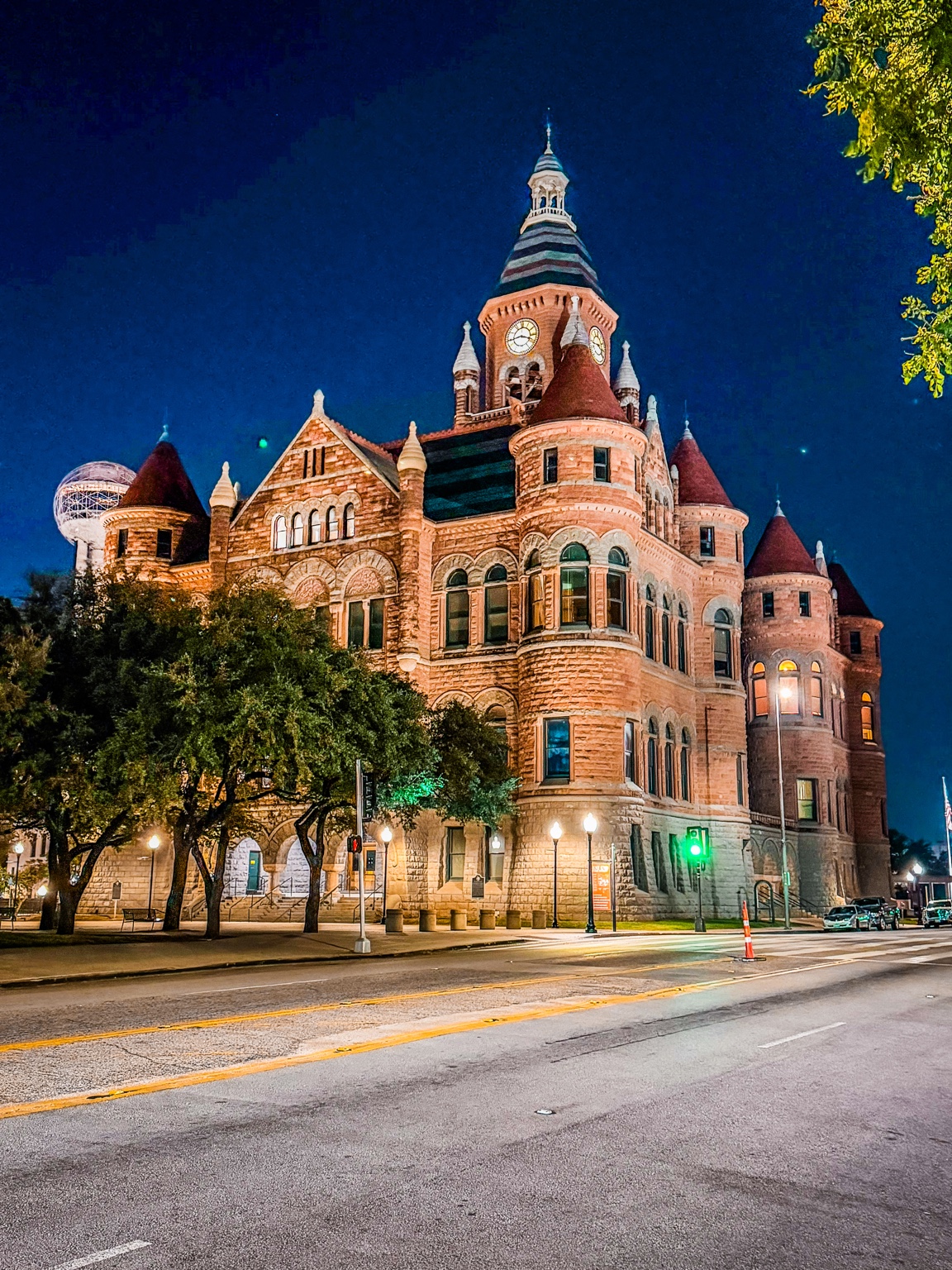 Red-brick courthouse and clock tower lit against a deep blue evening sky